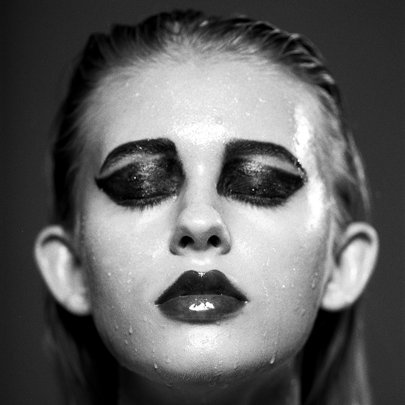 Monochrome portrait of Pia-Rebeca with sultry wet look makeup, shot by Anna Försterling.