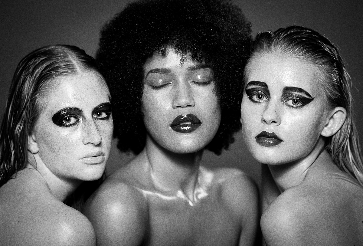High-end beauty photograph featuring three models with sultry wet look makeup, shot in black and white by Anna Försterling.