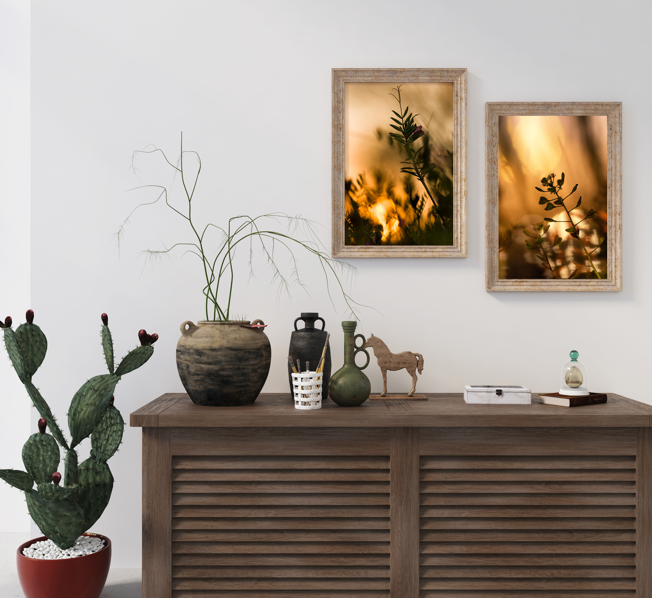 Close-up photographs of Vicia sepium and Shepherd's-Purse flowers framed in light wood frames on a wall. Underneath is a wooden sideboard with vases, potted plants, a cactus, a miniature horse figure, brushes, and a book.