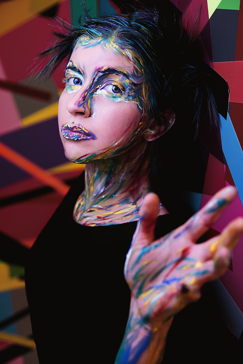 Portrait of model Mermaid Melancholia adorned in bold and colorful experimental makeup, creating a vibrant and artistic aesthetic.