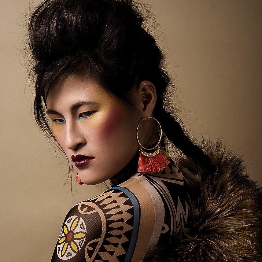High-fashion makeup portrait of model Bui in vibrant turquoise, red, and tan hues, captured by Vlada Migas.