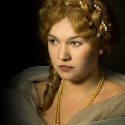"Transport yourself to the Romantic Era with Lisa V., elegantly adorned in a chignon hairstyle and period attire. 💖 Photographer, makeup artist, and hairstylist: Anett Alexandra Bulano. #RomanticEra #VictorianFashion" "Portrait of Lisa V. in Romantic Era attire, featuring a chignon hairstyle with a central braid adorned with pearls. Styled and photographed by Anett Alexandra Bulano."